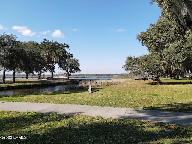 view of community with a water view and a yard