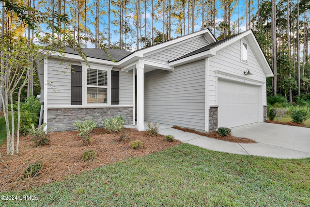 view of front facade featuring stone siding, a front lawn, an attached garage, and driveway