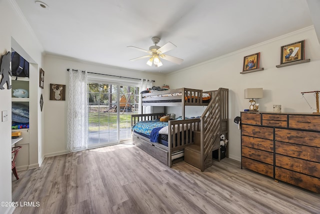 bedroom with access to outside, ornamental molding, wood finished floors, and baseboards