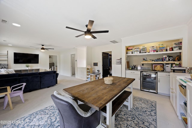 dining area with crown molding, a dry bar, visible vents, light carpet, and beverage cooler