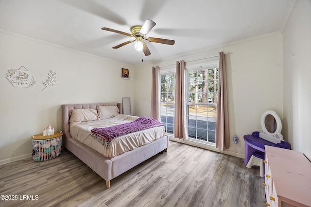 bedroom featuring baseboards, wood finished floors, and crown molding