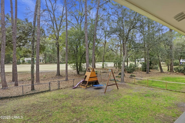 view of yard with a playground, fence, and visible vents