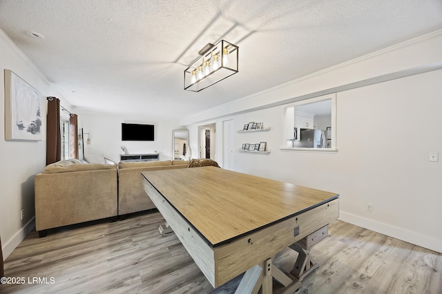 dining space with baseboards, light wood-style flooring, and a textured ceiling