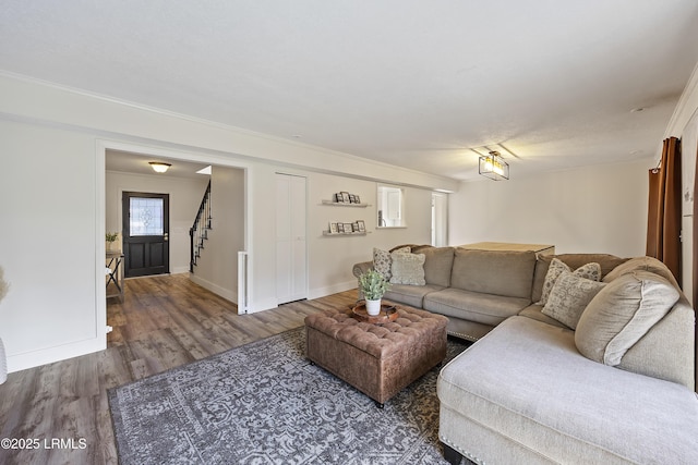 living area with wood finished floors, baseboards, and stairs