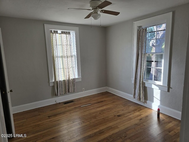 unfurnished room with ceiling fan, plenty of natural light, and dark hardwood / wood-style floors