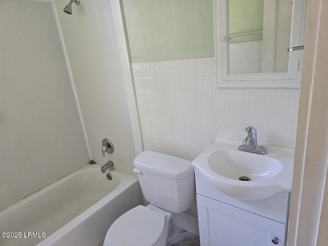 full bathroom featuring vanity, toilet, bathing tub / shower combination, and tile walls