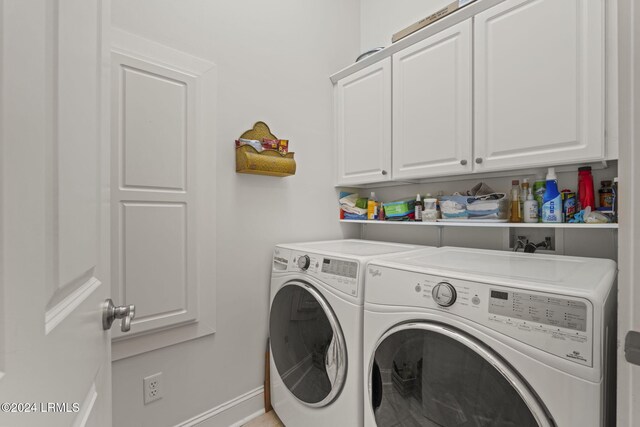 clothes washing area featuring cabinets and washing machine and dryer