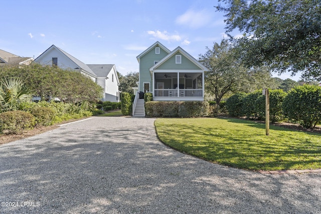 view of front of property featuring a sunroom, a front yard, and ceiling fan