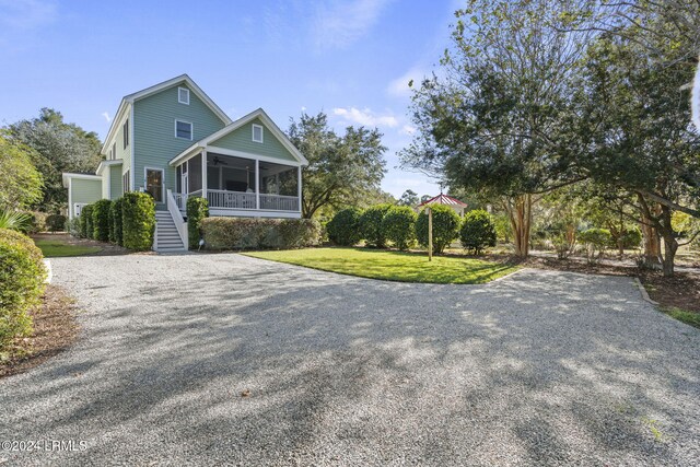 view of front facade with a front lawn and a sunroom