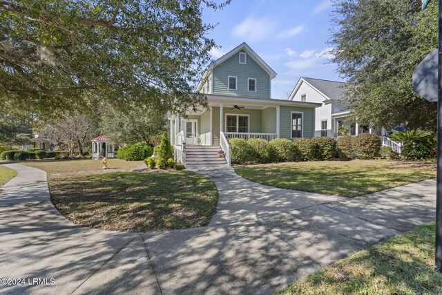 view of front of home with ceiling fan, a porch, and a front yard