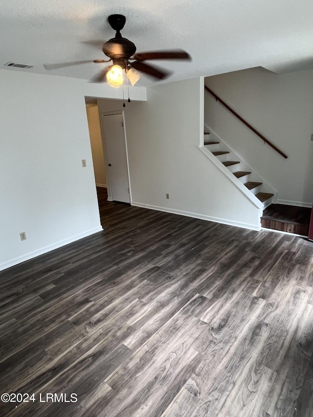 unfurnished room featuring dark wood-type flooring, ceiling fan, and a textured ceiling