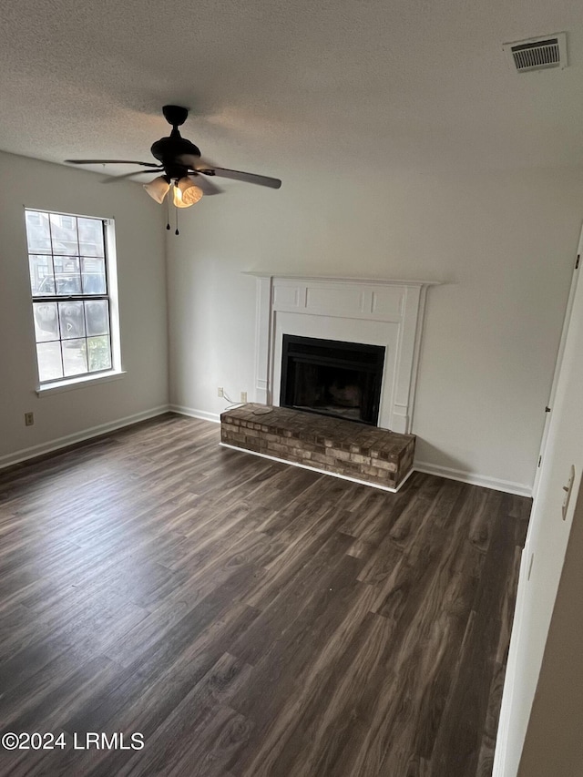 unfurnished living room with ceiling fan, dark hardwood / wood-style flooring, and a textured ceiling