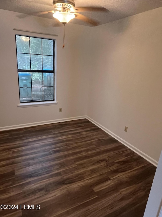 spare room with dark hardwood / wood-style flooring, ceiling fan, and a textured ceiling