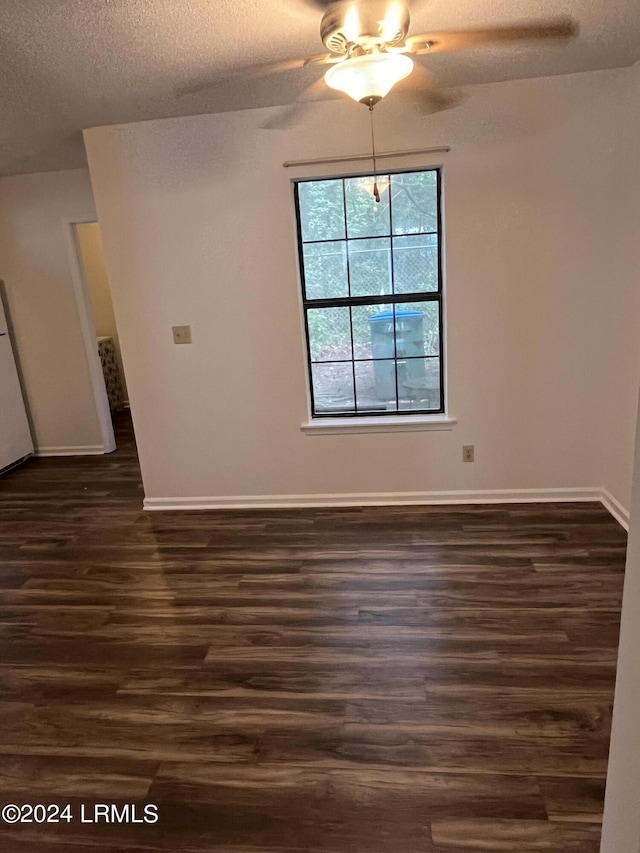 interior space featuring dark wood-type flooring, ceiling fan, and a textured ceiling