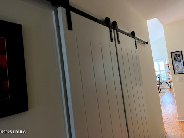 interior details with a barn door and wood finished floors