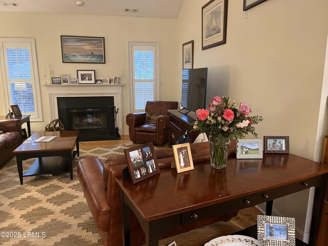 living room with a glass covered fireplace and visible vents