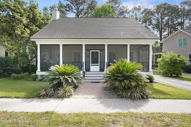 19 Brisbane Dr, Beaufort, SC 29902 - bungalow-style home featuring a chimney, a front lawn, a sunroom, and roof with shingles