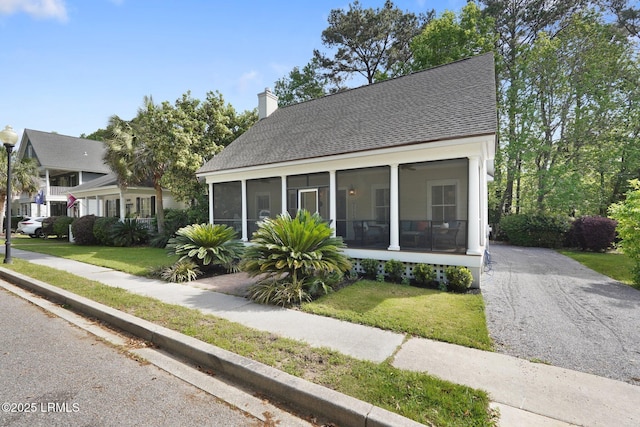 19 Brisbane Dr, Beaufort, SC 29902 - bungalow-style house featuring a front lawn, a shingled roof, a sunroom, and a chimney