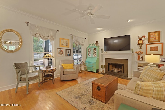 19 Brisbane Dr, Beaufort, SC 29902 - living room featuring light wood-style floors, ceiling fan, a fireplace, ornamental molding, and baseboards