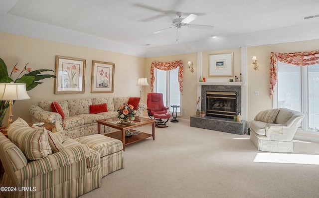 living room with ceiling fan, a premium fireplace, and carpet