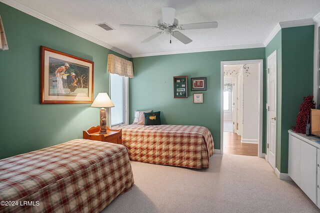 carpeted bedroom featuring crown molding, a textured ceiling, and ceiling fan