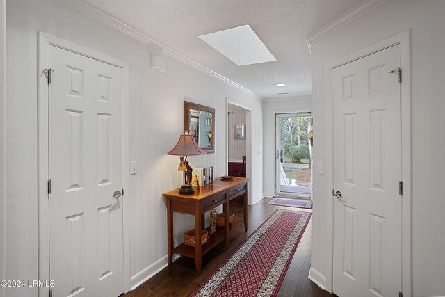 doorway to outside featuring a skylight, ornamental molding, dark hardwood / wood-style floors, and a textured ceiling