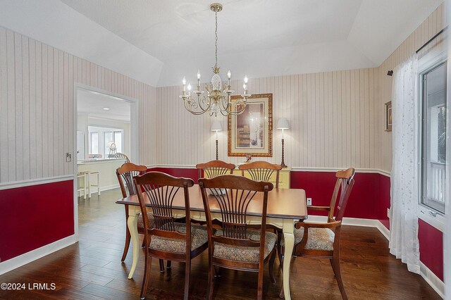 dining room featuring dark hardwood / wood-style floors, an inviting chandelier, and a tray ceiling