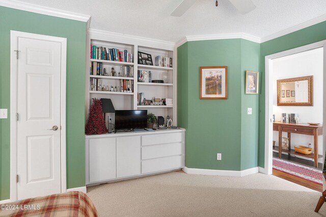 interior space featuring crown molding, light colored carpet, a textured ceiling, and ceiling fan