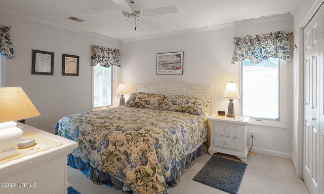 carpeted bedroom with ornamental molding, a closet, and ceiling fan