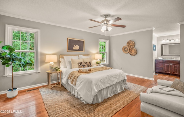 21 Planters Cir, Beaufort, SC 29907 - bedroom with light wood finished floors, crown molding, a textured ceiling, connected bathroom, and a ceiling fan