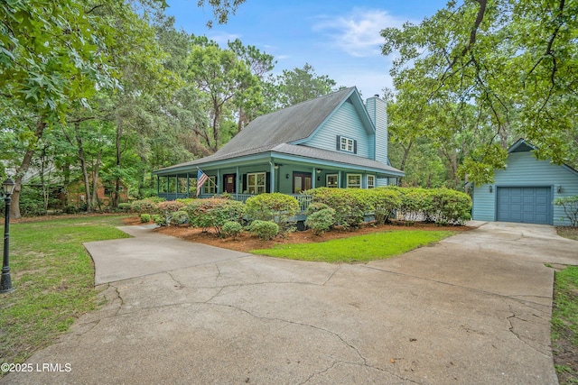 21 Planters Cir, Beaufort, SC 29907 - view of front of house featuring covered porch, concrete driveway, a chimney, a detached garage, and a front yard