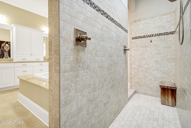 bathroom featuring tile patterned flooring, vanity, ornamental molding, and tiled shower