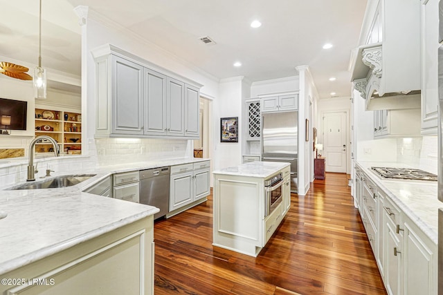 kitchen featuring stainless steel appliances, sink, backsplash, and light stone counters