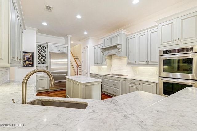 kitchen featuring light stone counters, sink, decorative backsplash, and appliances with stainless steel finishes