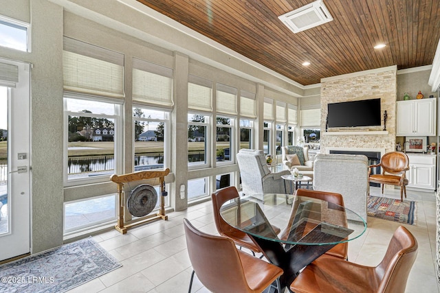 sunroom / solarium with wood ceiling and a fireplace