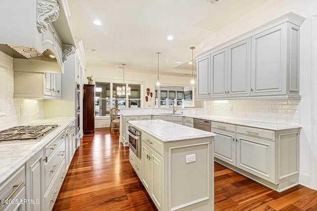 kitchen with a kitchen island, decorative light fixtures, decorative backsplash, light stone counters, and kitchen peninsula