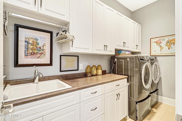 clothes washing area featuring cabinets, sink, light tile patterned floors, and independent washer and dryer