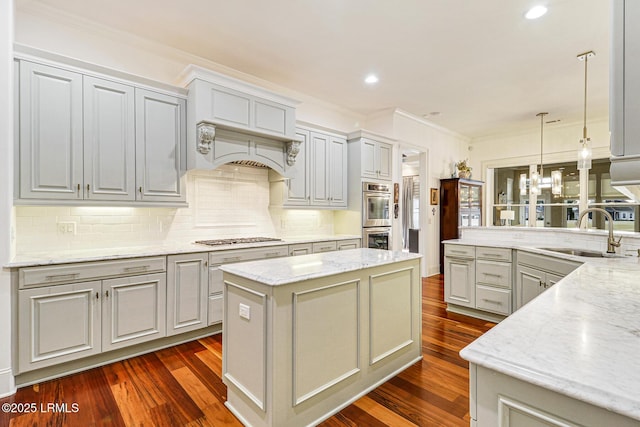 kitchen featuring light stone counters, sink, gray cabinetry, and a kitchen island