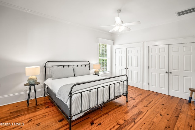 2211 Wilson Dr, Beaufort, SC 29902 - bedroom featuring ornamental molding, hardwood / wood-style floors, multiple closets, and a ceiling fan