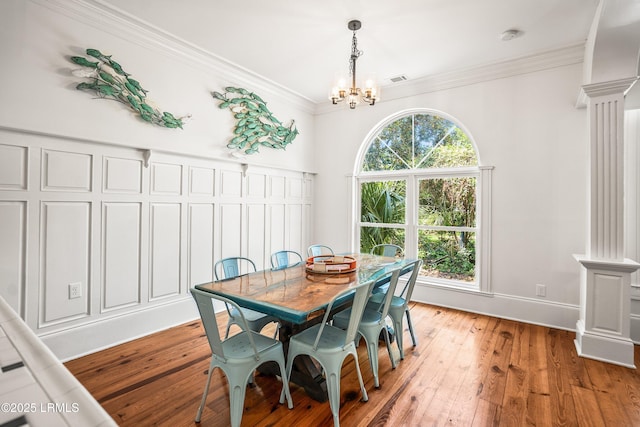 2211 Wilson Dr, Beaufort, SC 29902 - dining space featuring ornate columns, a chandelier, ornamental molding, and light wood-style floors