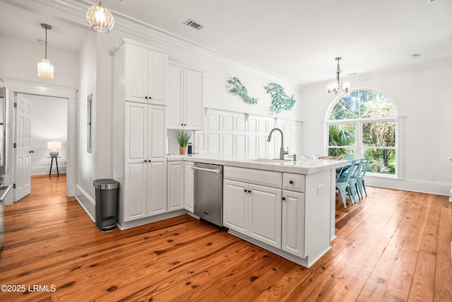 2211 Wilson Dr, Beaufort, SC 29902 - kitchen featuring stainless steel dishwasher, a peninsula, white cabinets, light wood-type flooring, and a chandelier