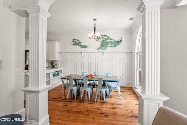 2211 Wilson Dr, Beaufort, SC 29902 - dining room with ornate columns, wood finished floors, ornamental molding, and a chandelier
