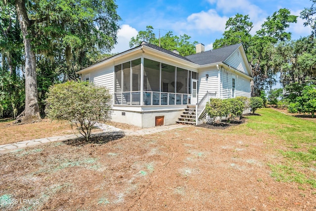 2211 Wilson Dr, Beaufort, SC 29902 - view of front of property with a sunroom, a chimney, and a front yard
