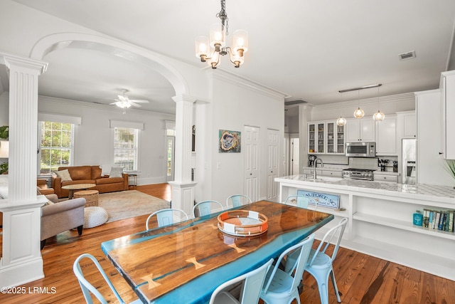 2211 Wilson Dr, Beaufort, SC 29902 - dining area with ornate columns, a ceiling fan, wood finished floors, ornamental molding, and arched walkways