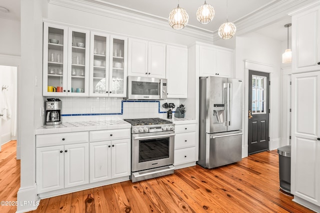 2211 Wilson Dr, Beaufort, SC 29902 - kitchen featuring stainless steel appliances, white cabinets, light wood-type flooring, decorative backsplash, and crown molding