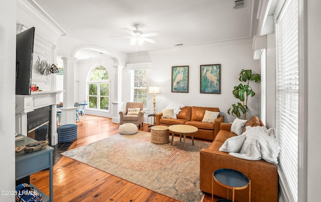 2211 Wilson Dr, Beaufort, SC 29902 - living room featuring decorative columns, ornamental molding, a ceiling fan, wood finished floors, and a tiled fireplace