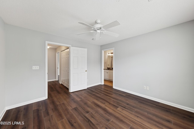 unfurnished bedroom with ceiling fan, dark wood-style floors, baseboards, and a textured ceiling