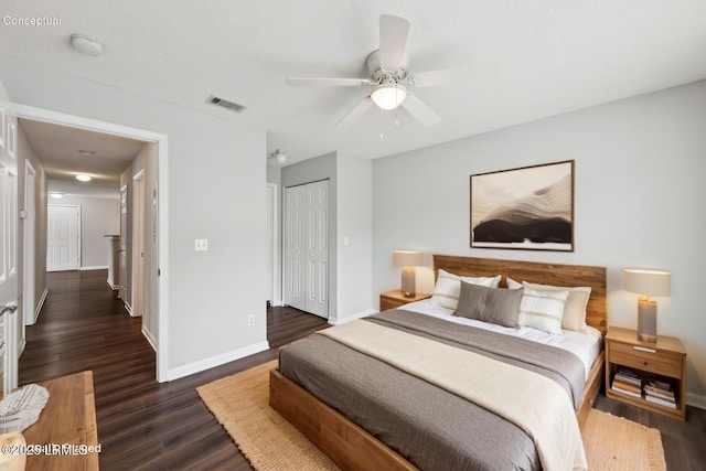 bedroom with visible vents, baseboards, dark wood finished floors, a closet, and a ceiling fan