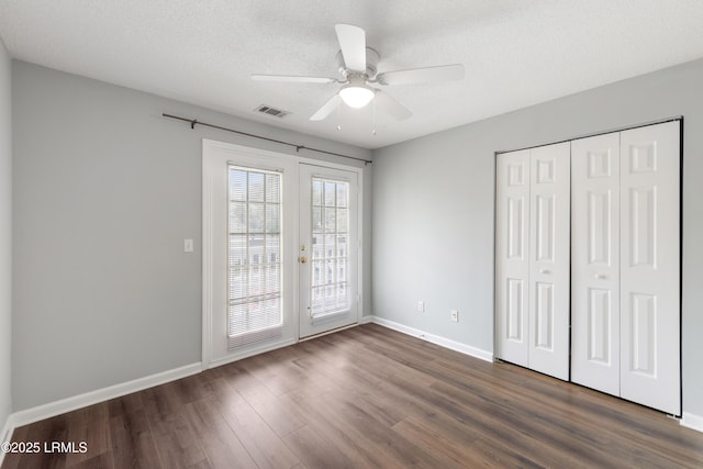 unfurnished bedroom with dark wood-style floors, french doors, baseboards, and access to outside