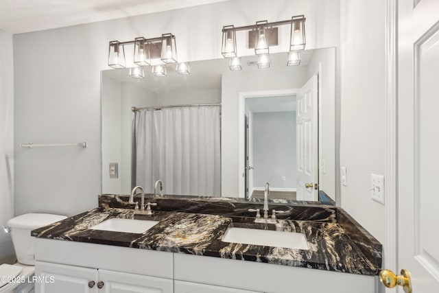 full bath with curtained shower, double vanity, toilet, and a sink